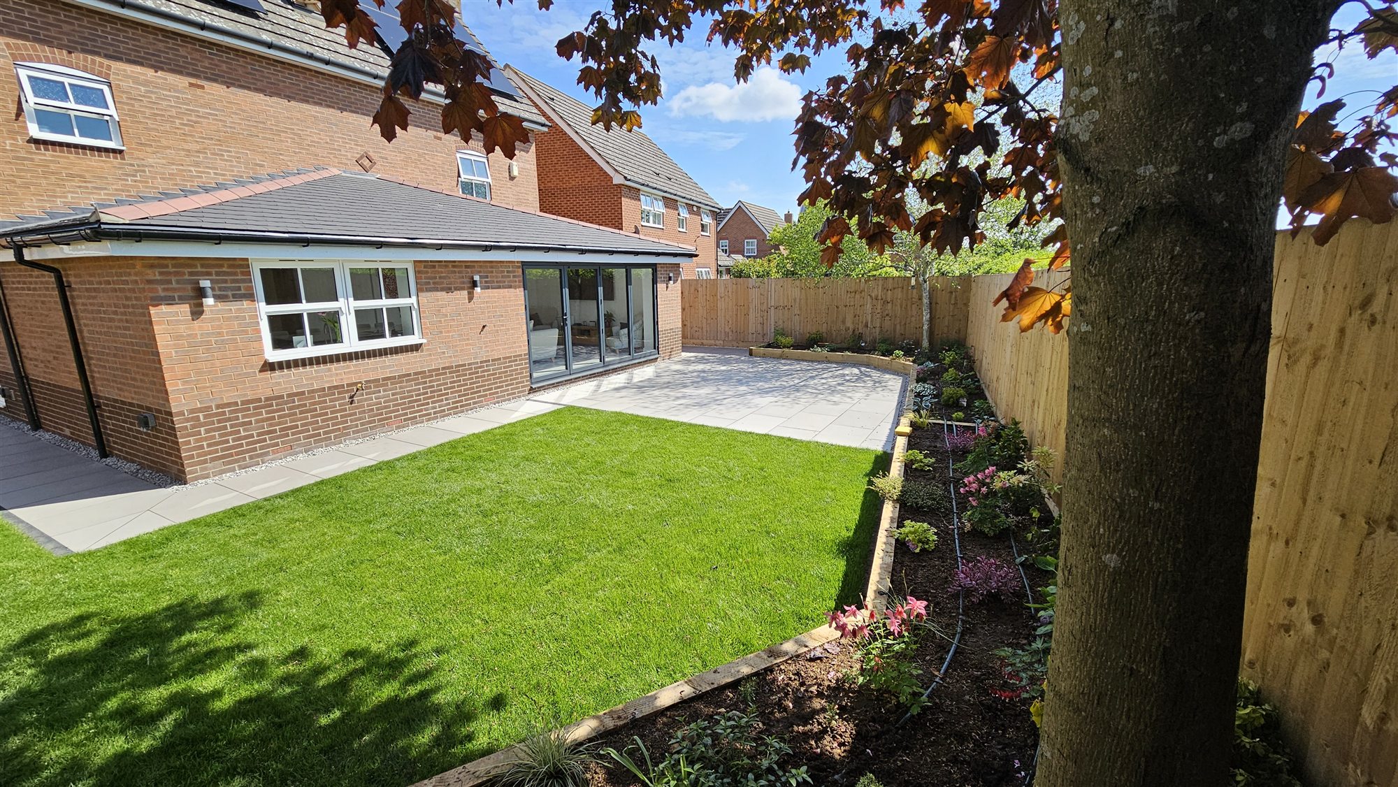 Oakham rear garden with porcelain terrace, lawn and planting after landscaping
