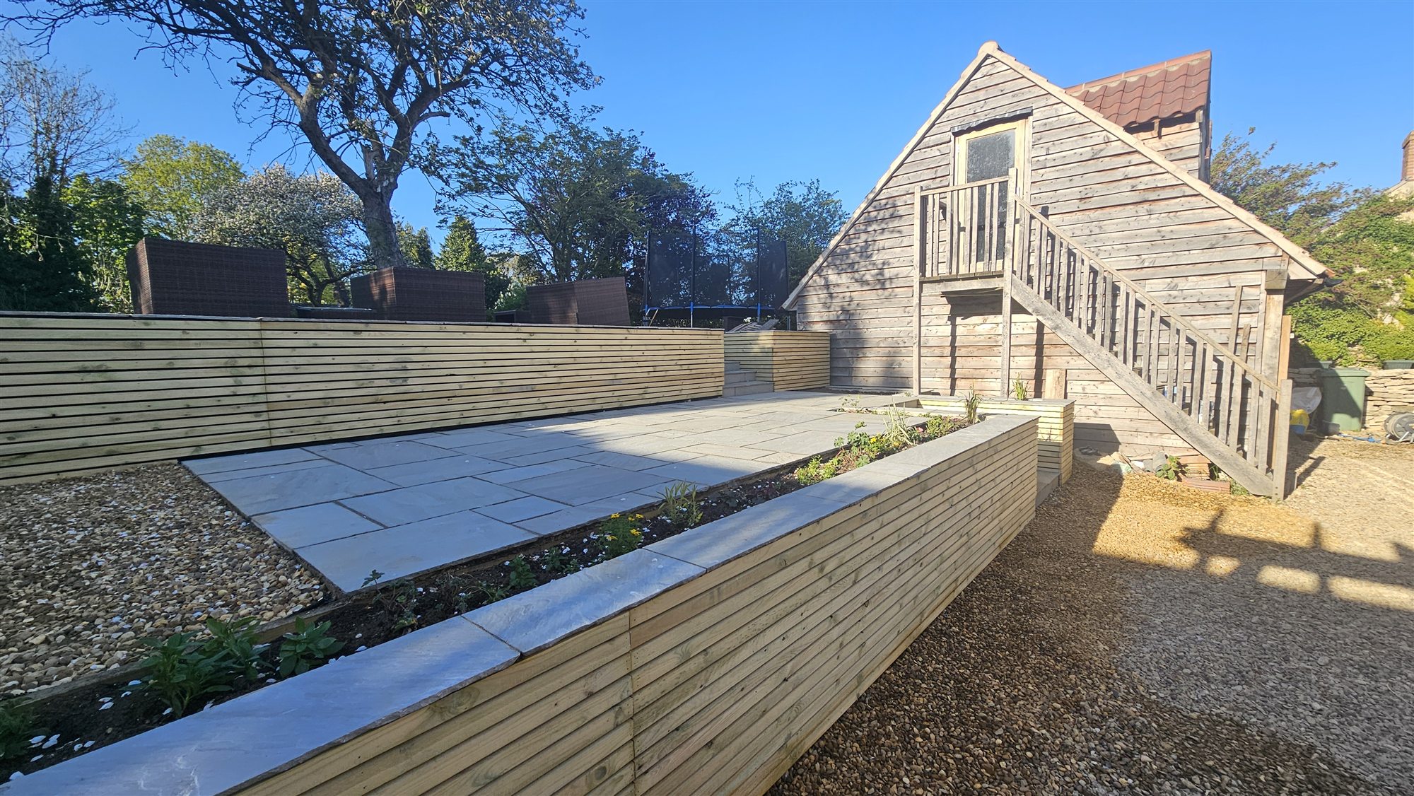 Ropsley garden with sandstone terrace, steps, gravel and planting