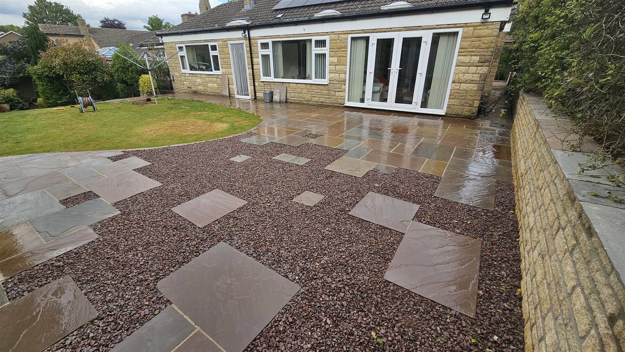 Greetham garden with sandstone paving and decorative gravel after transformation