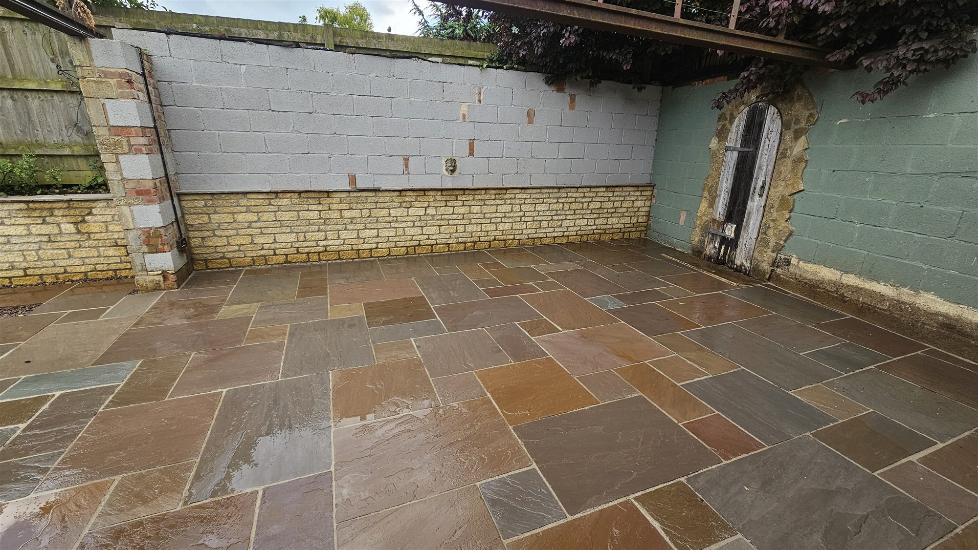 Sandstone terrace and renewed stone wall after landscaping